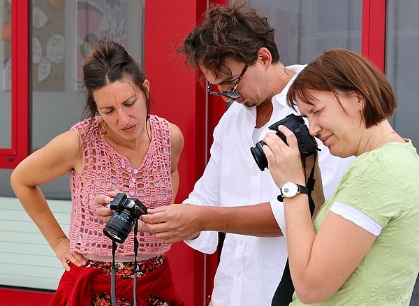 Drei Personen probieren Kameras aus